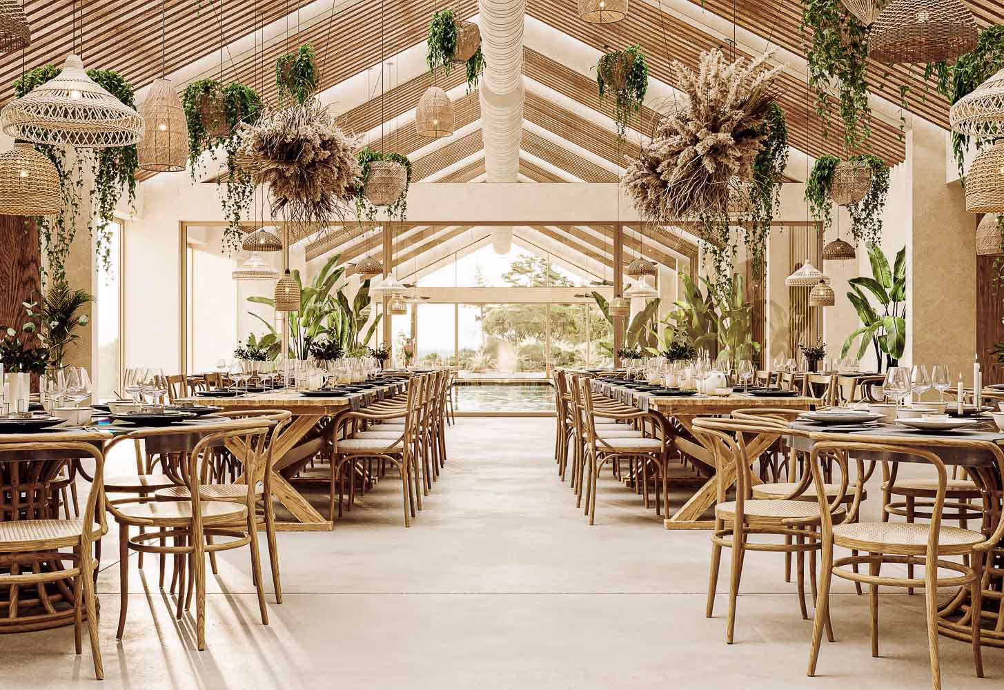 A spacious, elegantly decorated dining area with rustic wooden tables and chairs arranged symmetrically. Lush green plants and hanging light fixtures adorn the ceiling, creating a natural ambiance. Large windows at the end provide ample natural light.