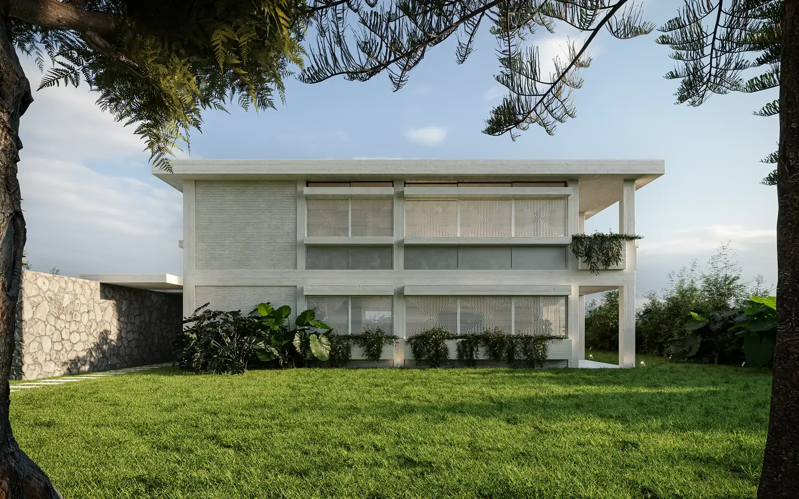 The house seen across a lawn from below: a low white two-storey volume with a continuous recessed upper gallery behind slender columns, a rough stone wall running along its base, and planting at the foot of the elevation.